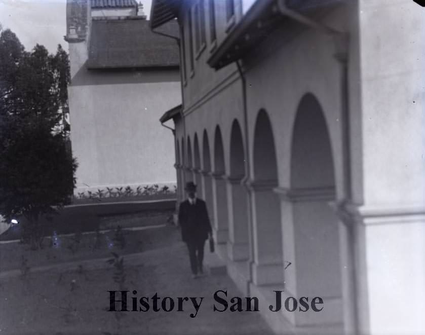 #121 Man walking in front of building, 1890s
