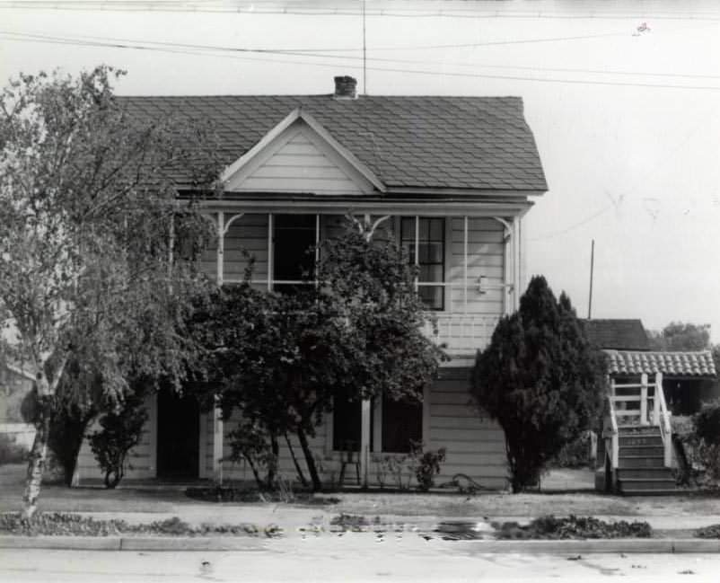 #161 Two-story home surrounded by vegetation, 1940