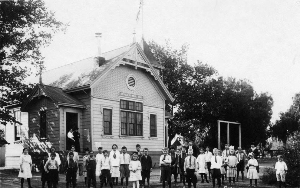 #200 About thirty children of various ages stand in front of Doyle School, 1910