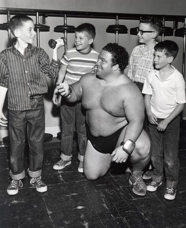 #116 Wrestler weight training with local fans, 1953