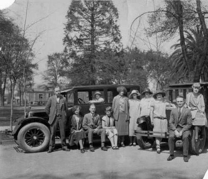 #64 Group of eleven men and women gathered on or near two cars by the campus of San Jose State Teachers College, 1919
