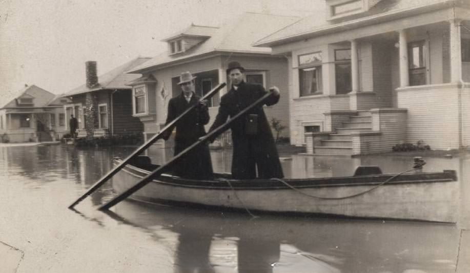 #86 Two people rowing a boat past houses on flooded Viola Avenue. (Viola was between Market Street and Orchard Street (Almaden Road), 1911