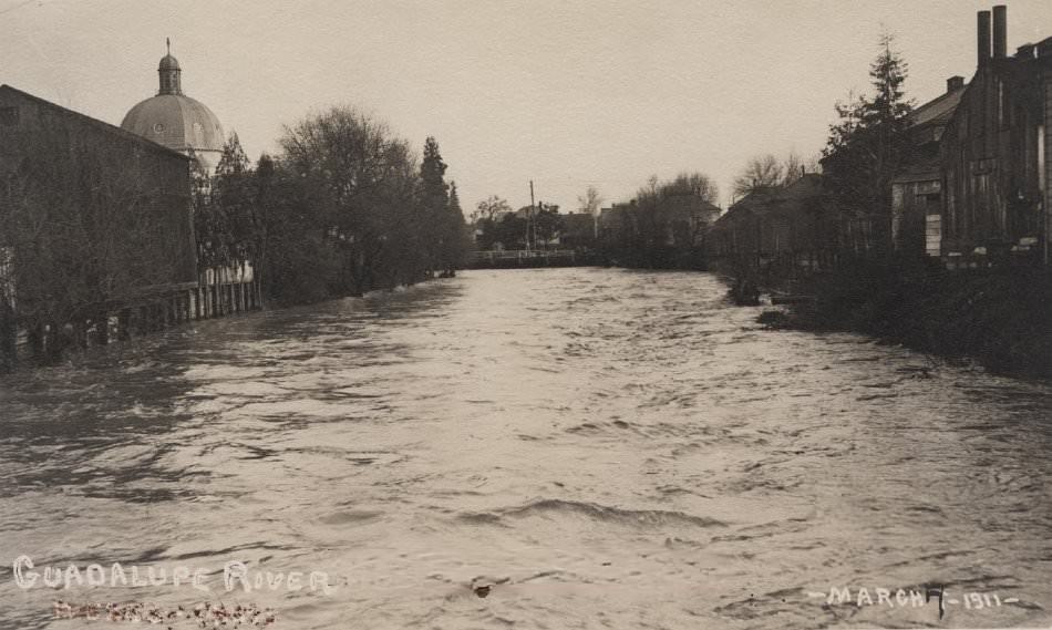 #87 View of the Guadalupe River during flood of March 7, 1911 with buildings and Holy Family church dome in the background