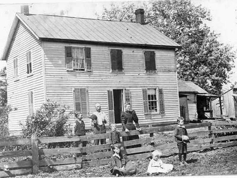 #10 A man and woman stand outside a house with children at the Carty house in Ridgefield, 1890