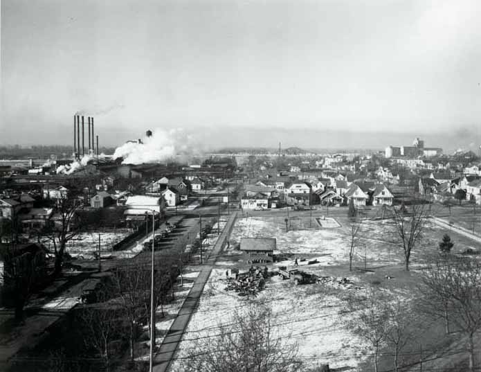 #41 A view of 6th Street along Esther Short Park, 1930s. The railroad bridge is visible in the distance.