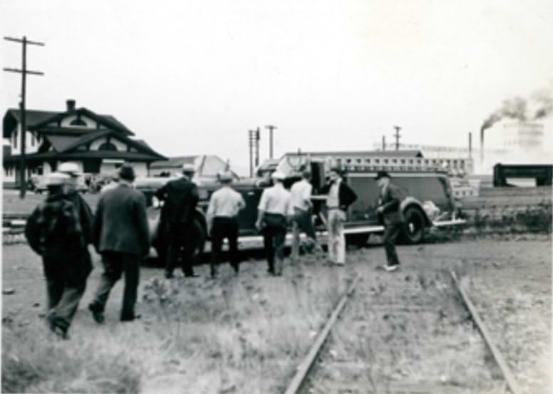 #32 Men stand around a fire truck with a ladder parked near the train station in Vancouver, 1940