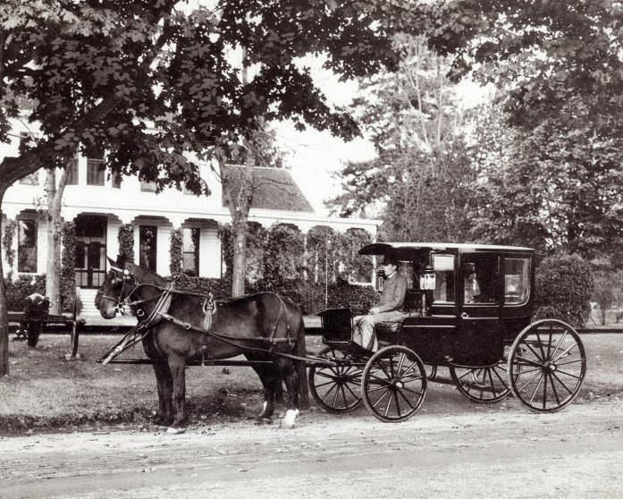 #14 A black carriage with a team of horses and a driver in an overcoat and top hat sits in front of a house on Officers Row, 1890s