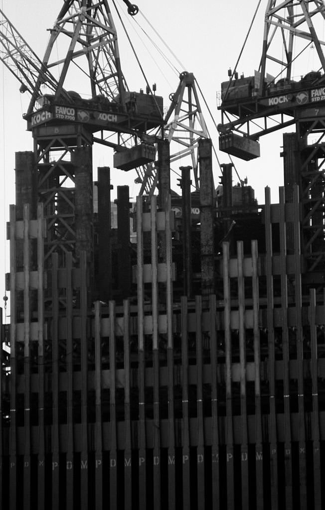 #30 Construction cranes sit on top of a partially constructed Tower One of the World Trade Center in the winter of 1970