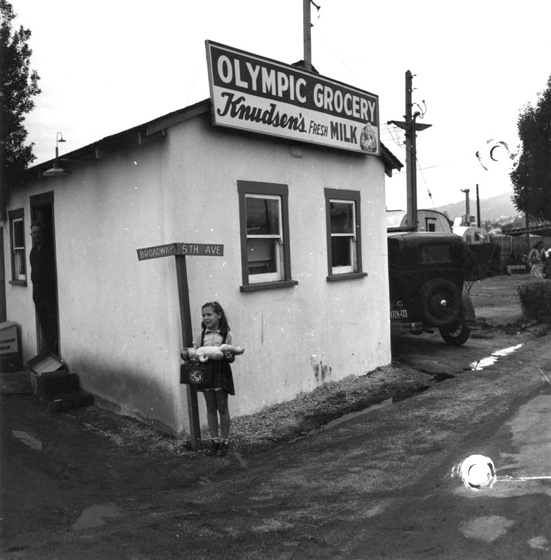 #71 A young girl outside a market at Olympic Trailer Court.