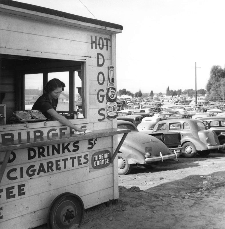 #76 A woman wiped off the counter of a lunch stand near an aircraft plant in the Los Angeles area.