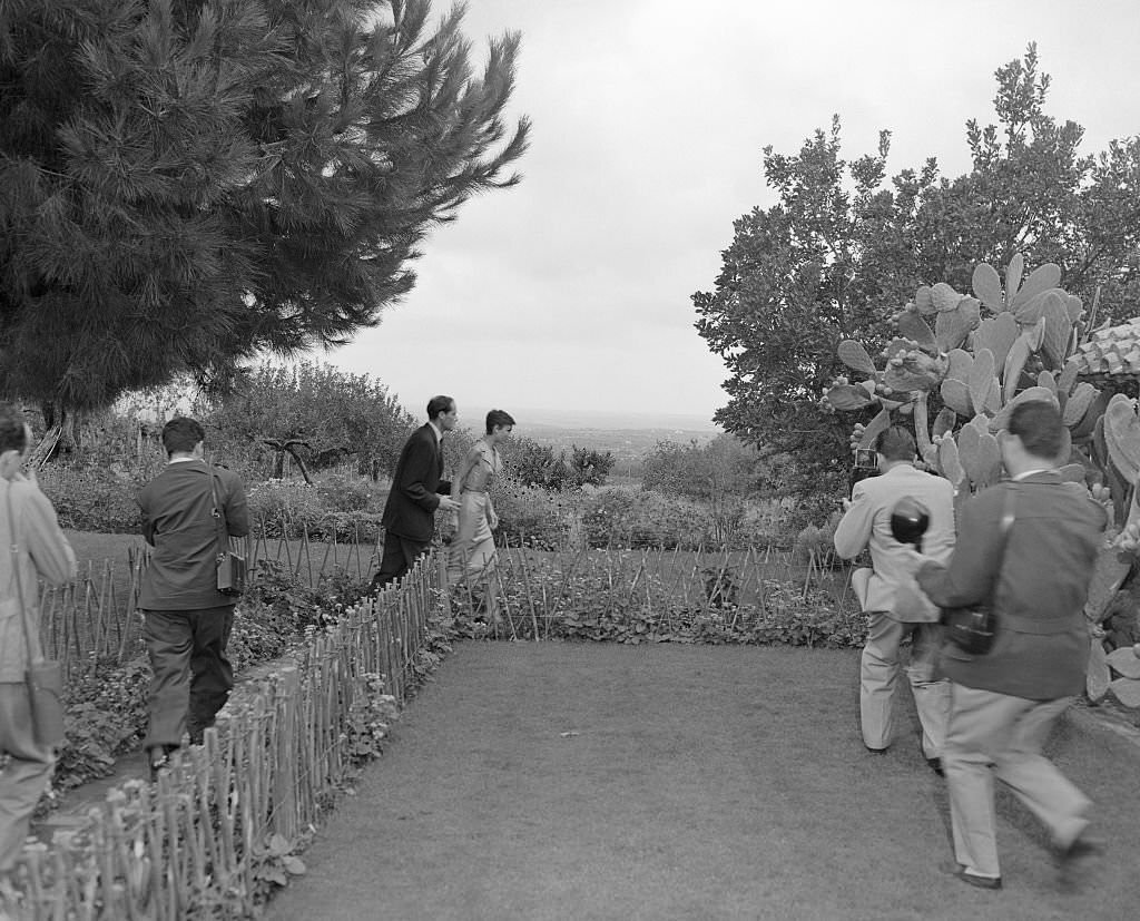 #39 Newlyweds Audrey Hepburn and Mel Ferrer flee photographers on the grounds of the villa near Albano where they are honeymooning.
