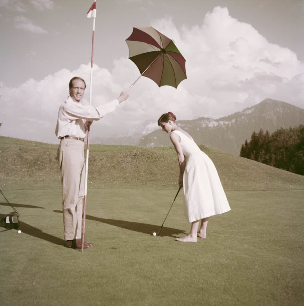 #49 Audrey Hepburn and Mel Ferrer on a golf course at the Bürgenstock resort, Switzerland, 1954.
