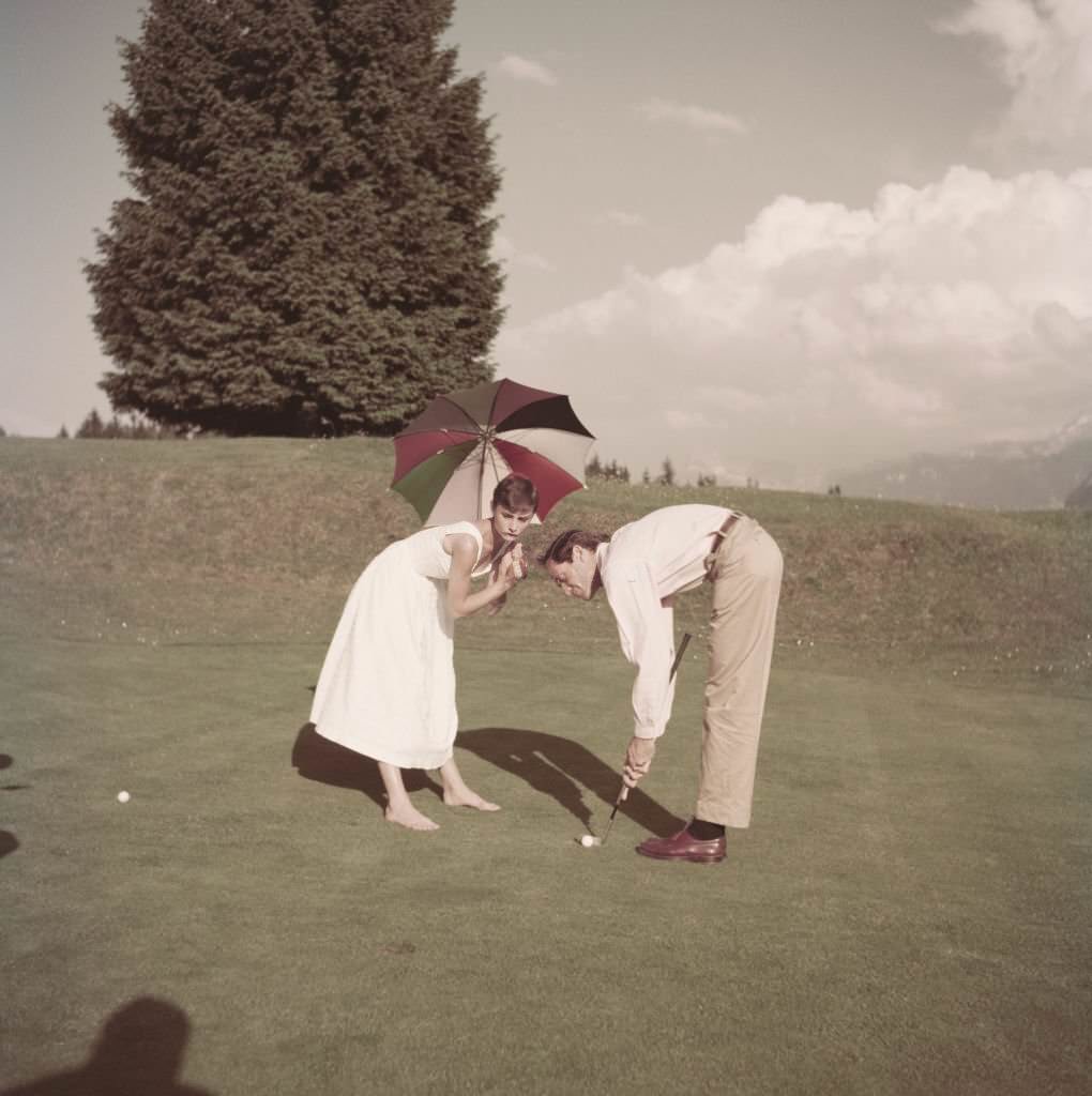 #53 Audrey Hepburn and Mel Ferrer on a golf course at the Bürgenstock resort, Switzerland, 1954.