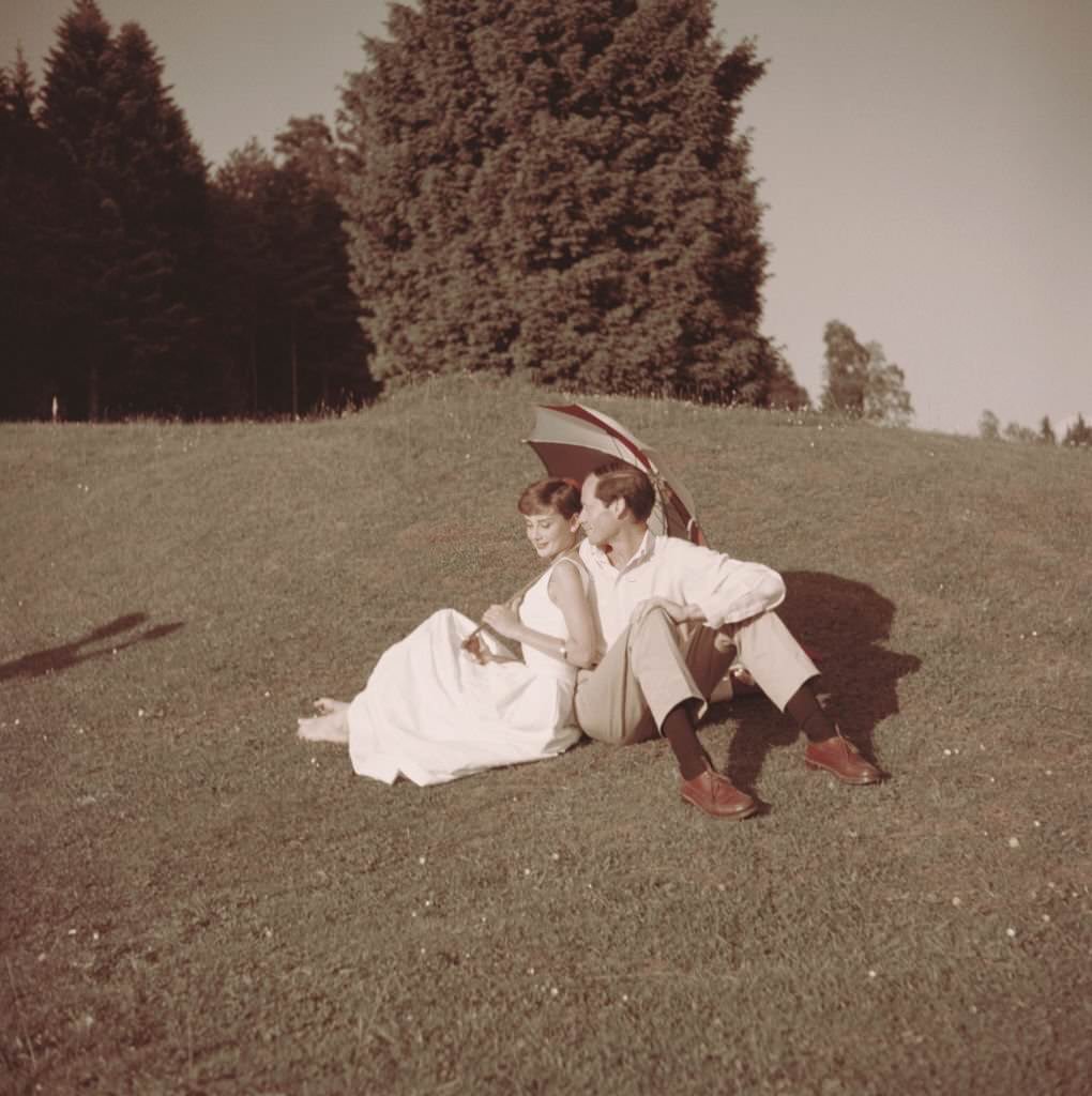 #56 Audrey Hepburn with her husband Mel Ferrer on a golf course at the Bürgenstock resort, Switzerland, 1954.
