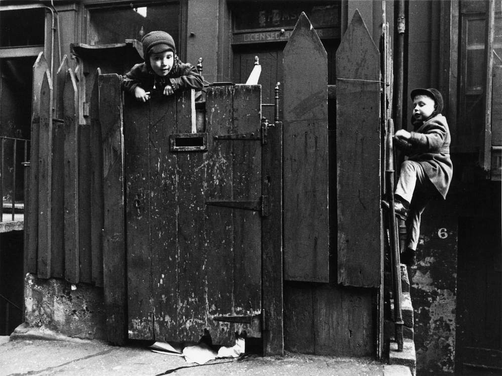 #67 Children climbing fencse outside the pub, Edinburgh, 1965