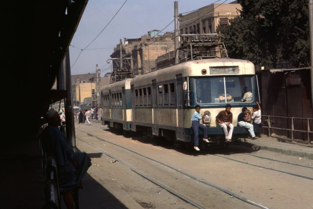 #19 Stowaways hanging from a tramway in Cairo, 1983