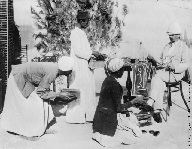 #134 Egyptian bootblacks cleaning a European’s shoes in Cairo, 1870