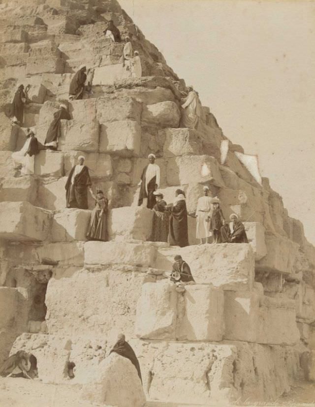 #61 European tourists and local guides climb one of the pyramids at Giza