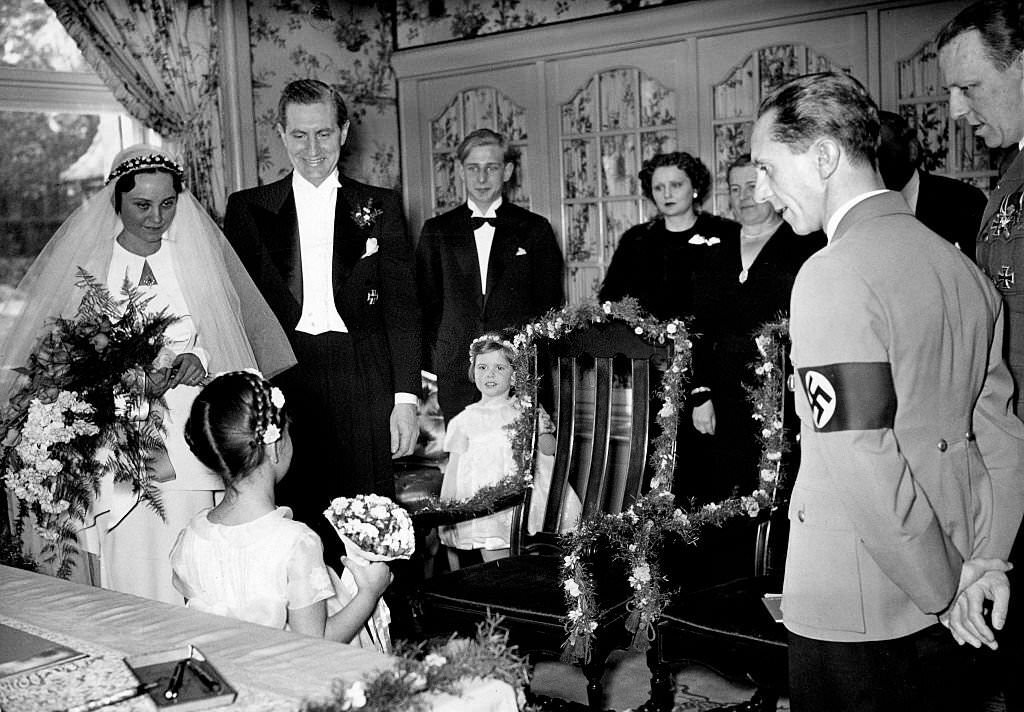 #34 Joseph Goebbels on the occasion of his sisters marriage, his sister Maria and her husband, film director Max Kimmich, getting flowers from Goebbels’ daughter Helga, 1938