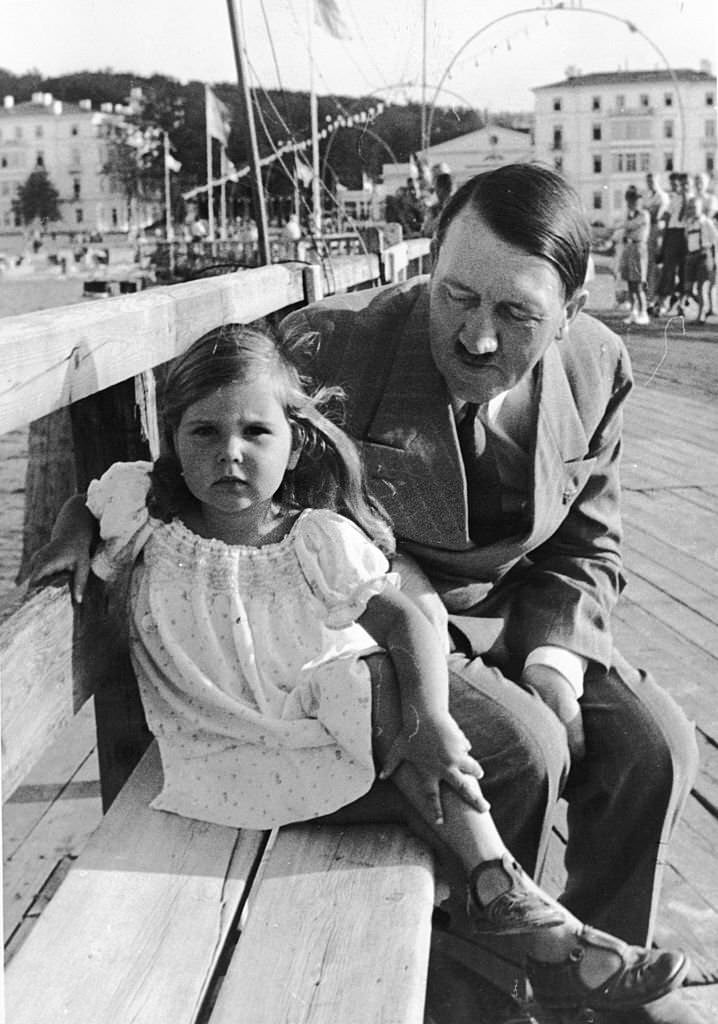 #50 Adolf Hitler sitting on a bench with Helga Goebbels, daughter of Nazi propagandist Paul Joseph Goebbels.