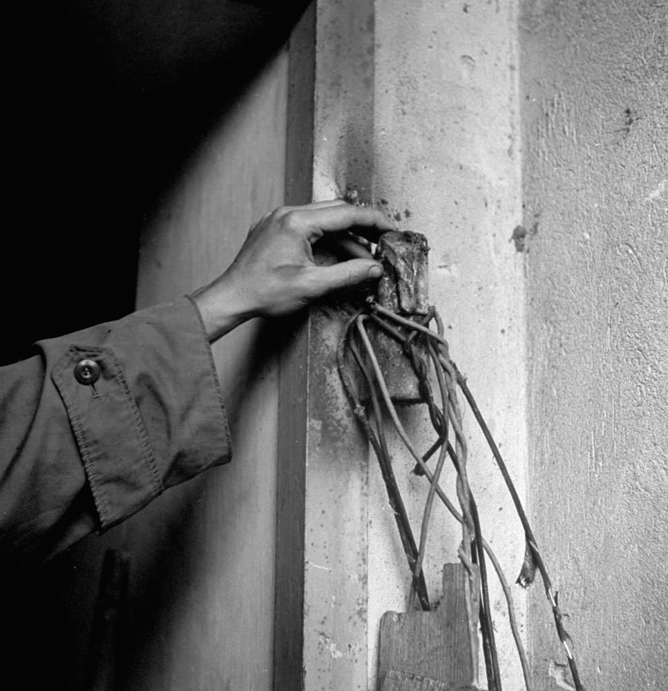#14 An unidentified hand on the destroyed hinge of the door to Hitler’s bunker, burned off by advancing Russian combat engineers, Berlin, 1945.