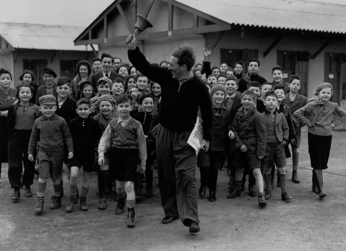 #1 A camp leader rings the dinner bell for refugees at the Dovercourt holiday camp, 1939.