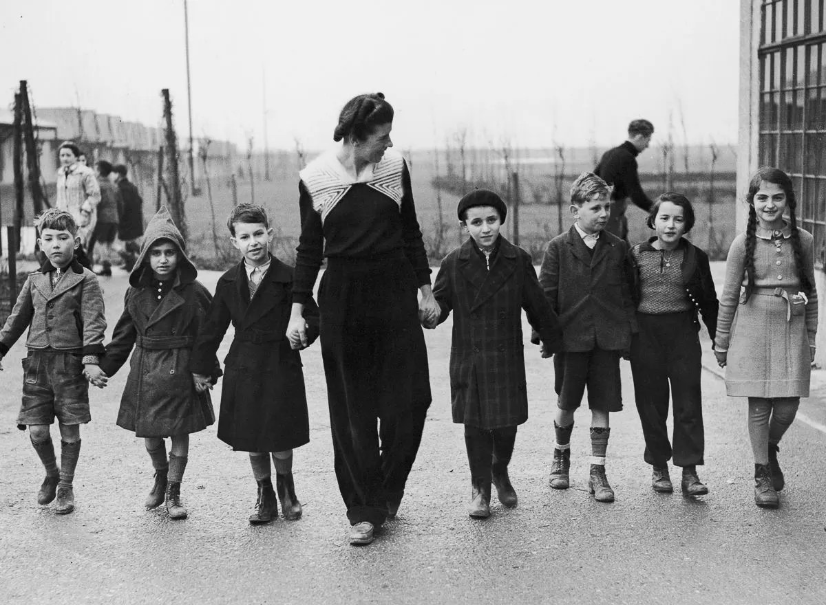 #18 Miss W. Herford leads refugee children on a walk at the Dovercourt holiday camp, 1939.