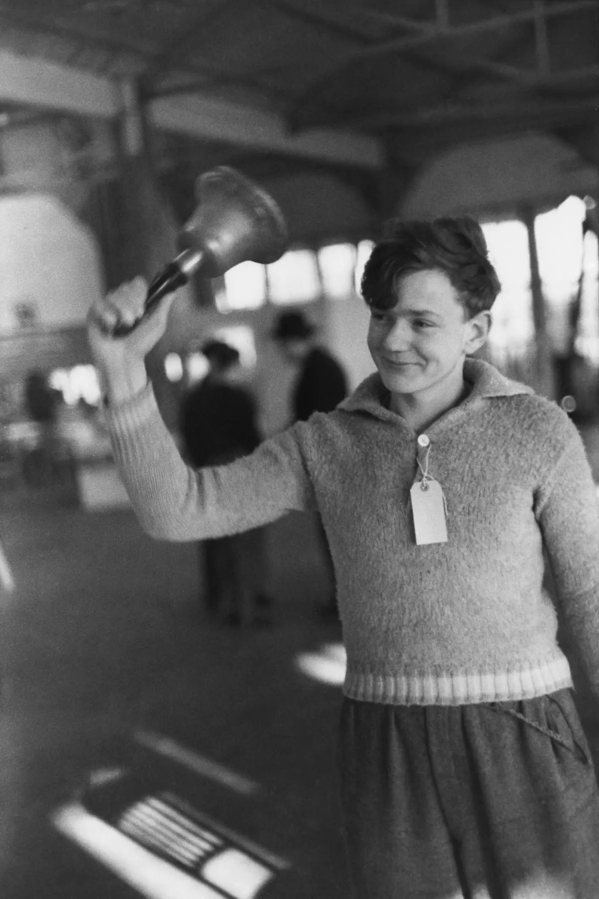 #20 A refugee rings the dinner bell at the Dovercourt holiday camp, 1938.