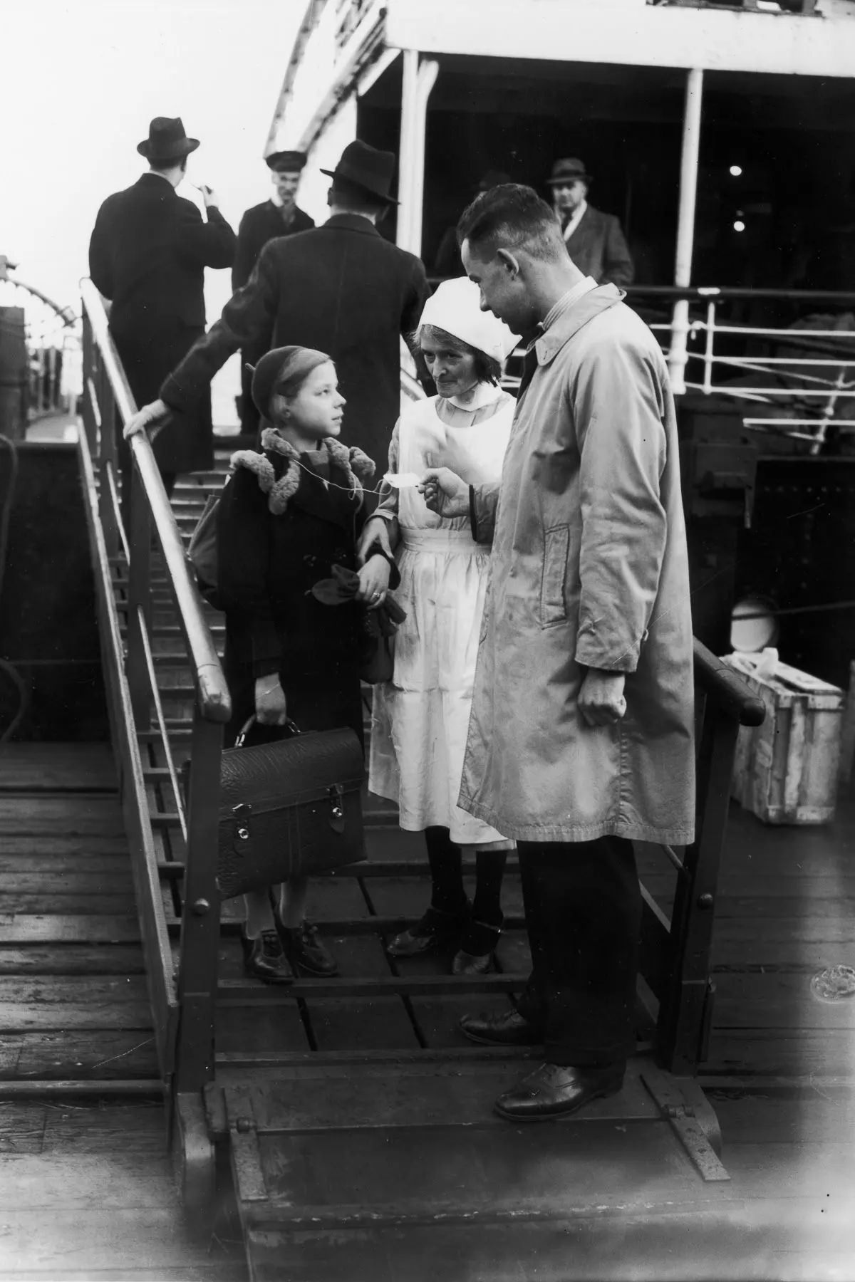 #4 German-Jewish girl Helga Samuel is met by a Kindertransport agent upon arriving in Harwich. December 2, 1938.