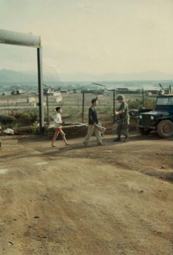 #8 A Vietnamese man and boy, treated as prisoners, walking along being stopped by an Army soldier in the 2nd Battalion.