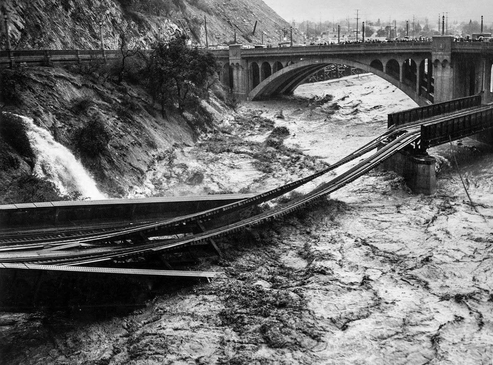 #16 Floodwaters in Los Angeles River destroy Southern Pacific railroad bridge. The photo was taken from North Figueroa Street bridge, 1938