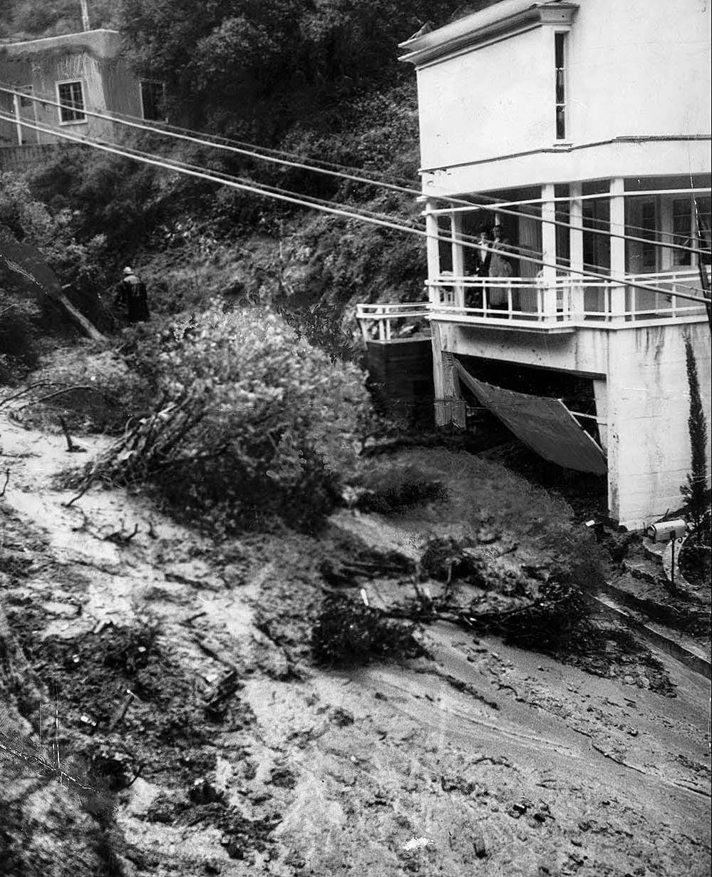 #27 Water-soaked earth moved rapidly down the side of Laurel Canyon at Kirkwood Avenue, carrying trees and boulders in its path and wrecking the basement garage of this home, 1938