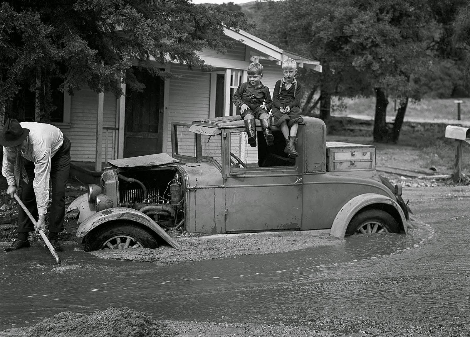 #29 William L. Griffin digs out the family car on the 1700 block of Fernlane Street as Lloyd Griffin and David Stagg watch, 1938