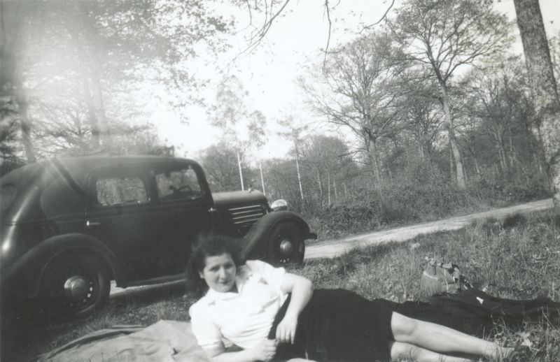 #11 A young woman in a white blouse and a dark skirt seductively lying on a picnic blanket, 1938