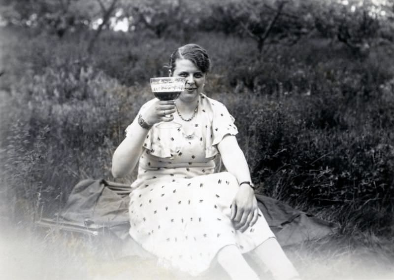 #6 A young lady raising her glass in a meadow in the countryside, 1935