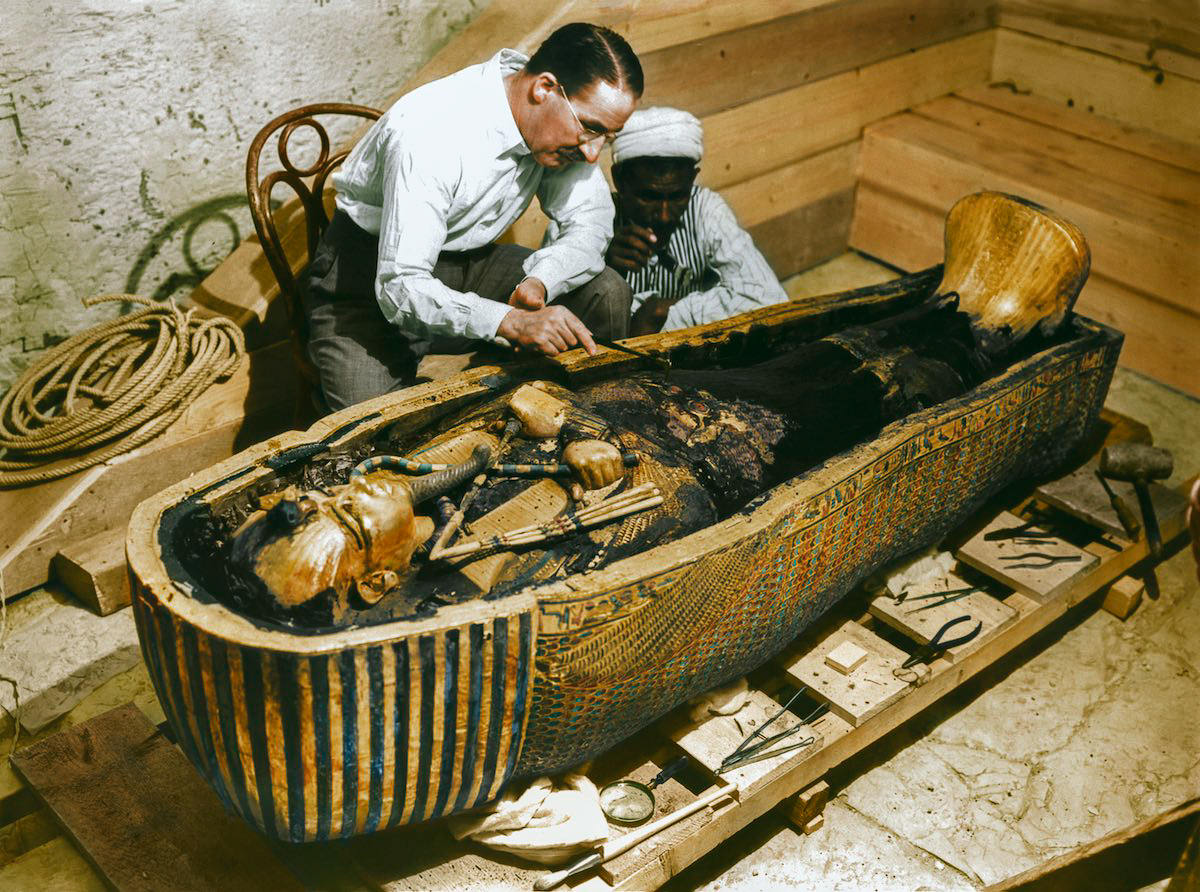 Carter and an Egyptian workman examine the third (innermost) coffin (Carter no. 255) made of solid gold, inside the case of the second coffin. Tutankhamun’s Tomb, 30th October 1925