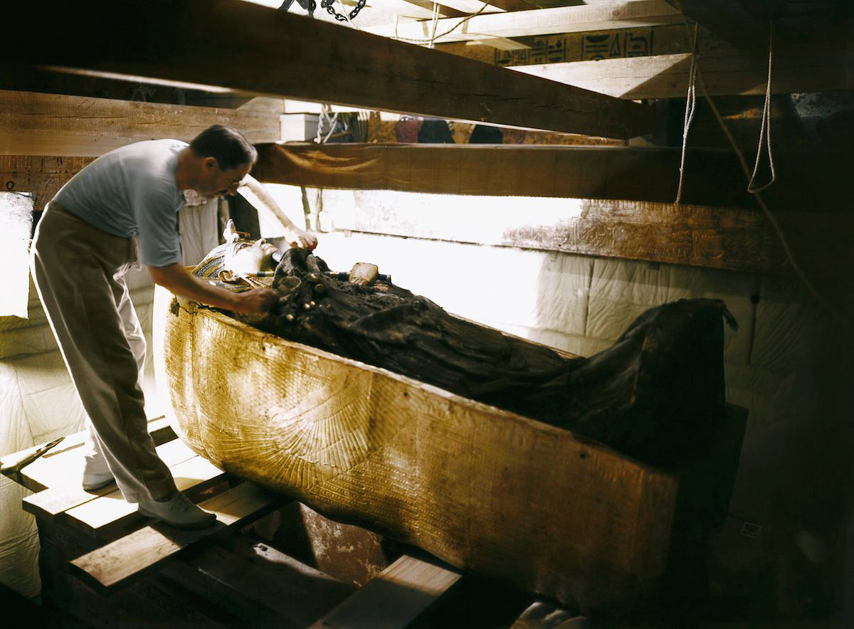 Howard Carter working on the lid of the second (middle) coffin, still nestled within the case of the first (outermost) coffin in the Burial Chamber. Tutankhamun’s Tomb, October 1925
