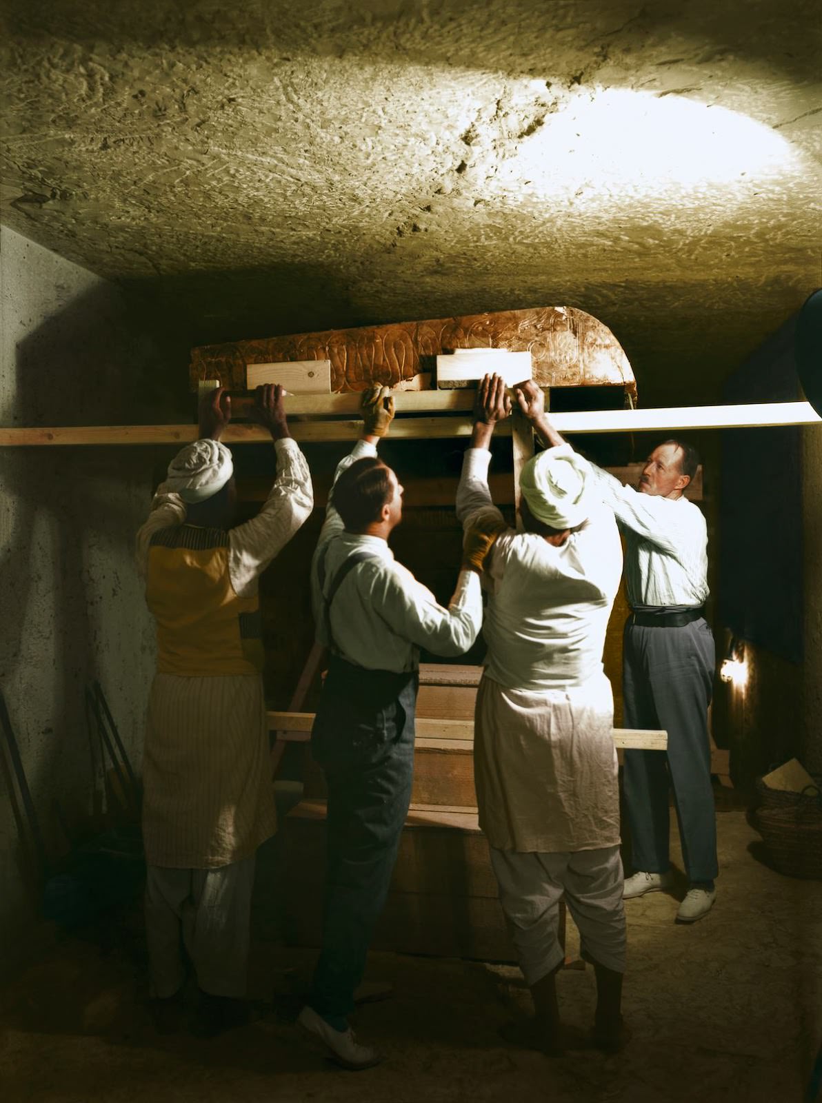 Howard Carter (centre), Arthur Callender and two Egyptian workmen lifting one roof section from the first, outermost shrine (Carter no. 207). Tutankhamun’s Tomb, December 1923
