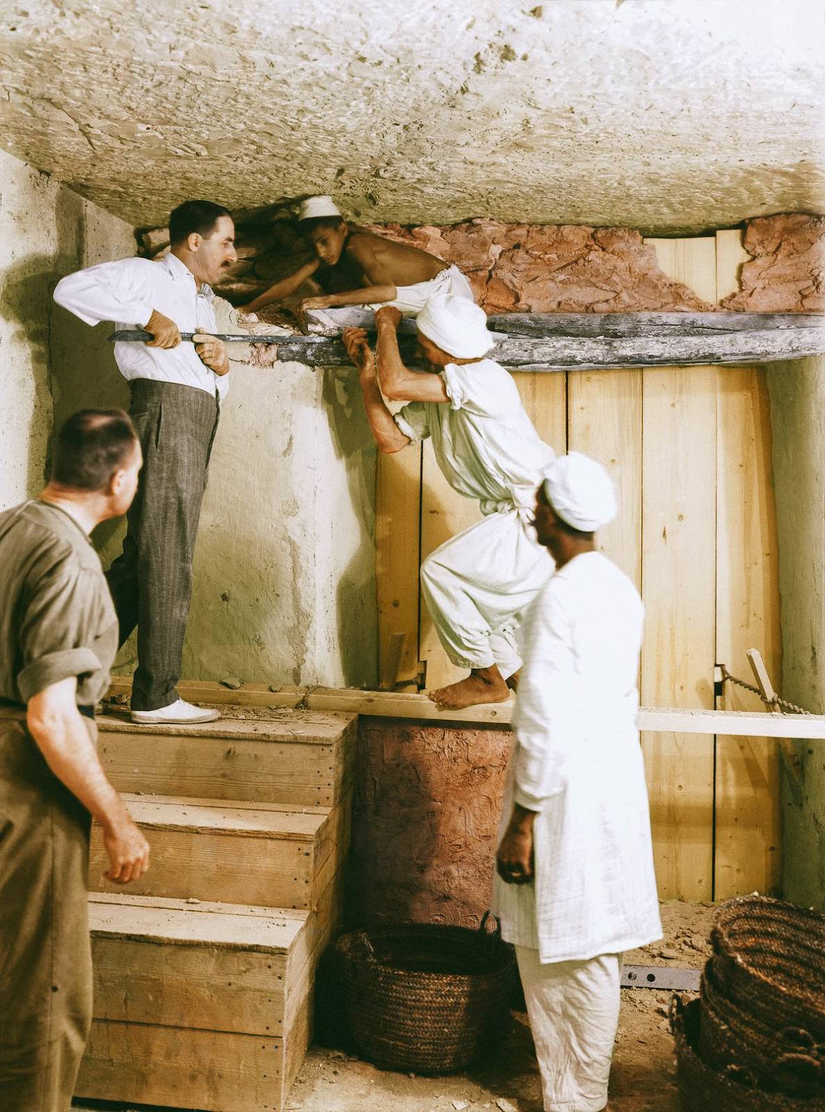 Howard Carter (at the top of the stairs), Arthur Callender and Egyptian workmen removing the wall between the Antechamber and the Burial Chamber to enable the dismantling of the four golden shrines enclosing the sarcophagus. Tutankhamun’s Tomb, 2nd December 1923