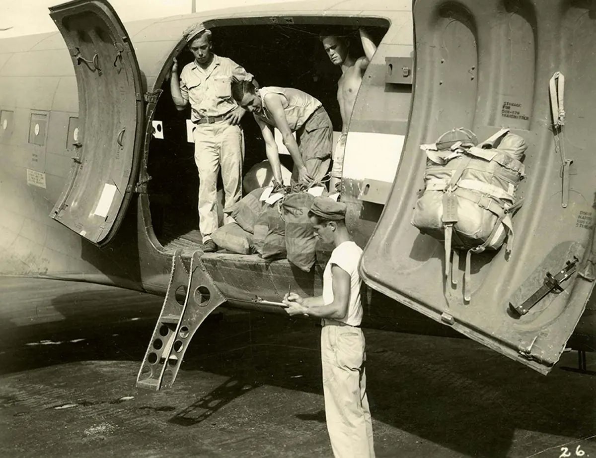 #25 The final act at the airstrip with the mail truck, containing letters for the States and for the troops, pulled alongside the plane. Port Moresby, Papua New Guinea, 1944.