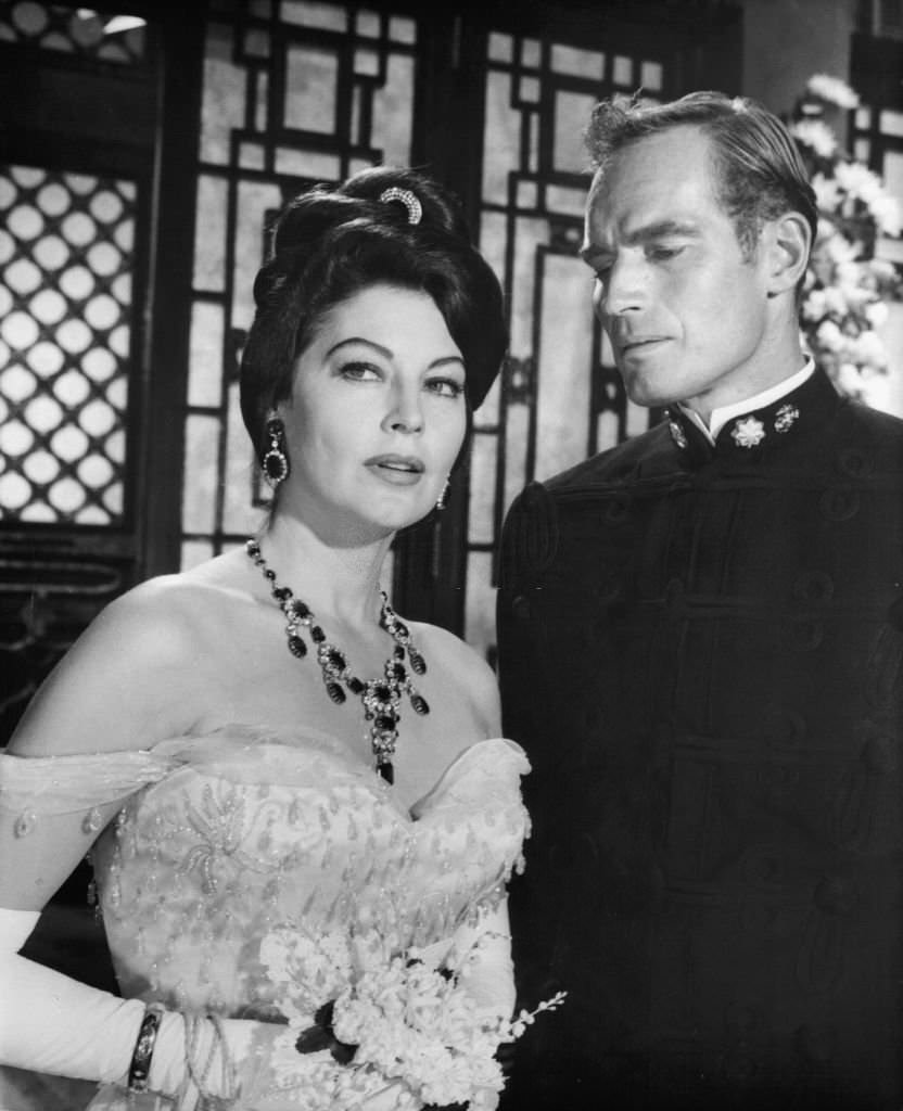 Ava Gardner is escorted by Charlton Heston in a scene from the film ’55 Days At Peking’, 1963.