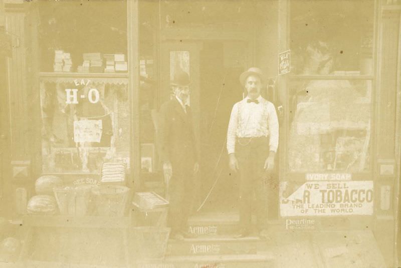 #15 Two men outside grocery store, 1880s