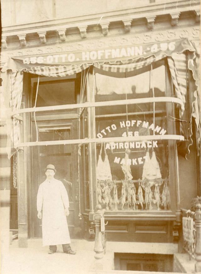 #19 Butcher standing outside Otto Hoffmann Adirondack Market, 1890s