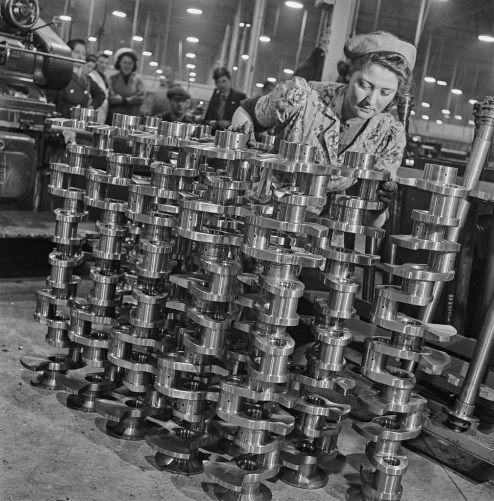 #108 A female factory worker polishes completed crankshafts for fitting in Rolls-Royce Merlin V-12 piston aero engines at the Hillington Rolls-Royce aero engine factory in Glasgow, Scotland on 30th November 1942.
