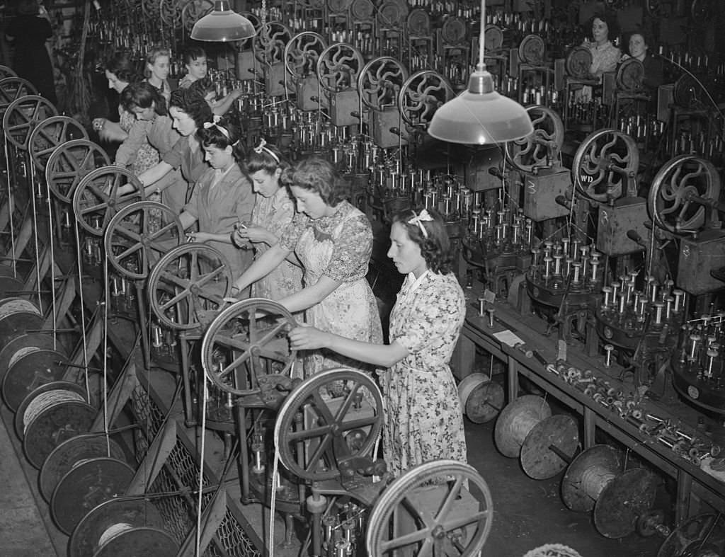 #115 The seven Mills sisters work side by side at a munitions factory in Enfield during World War II. From left to right, they are Kitty, Beryl, Irene, Marjorie, Doris, Phyllis and Violet, 1942