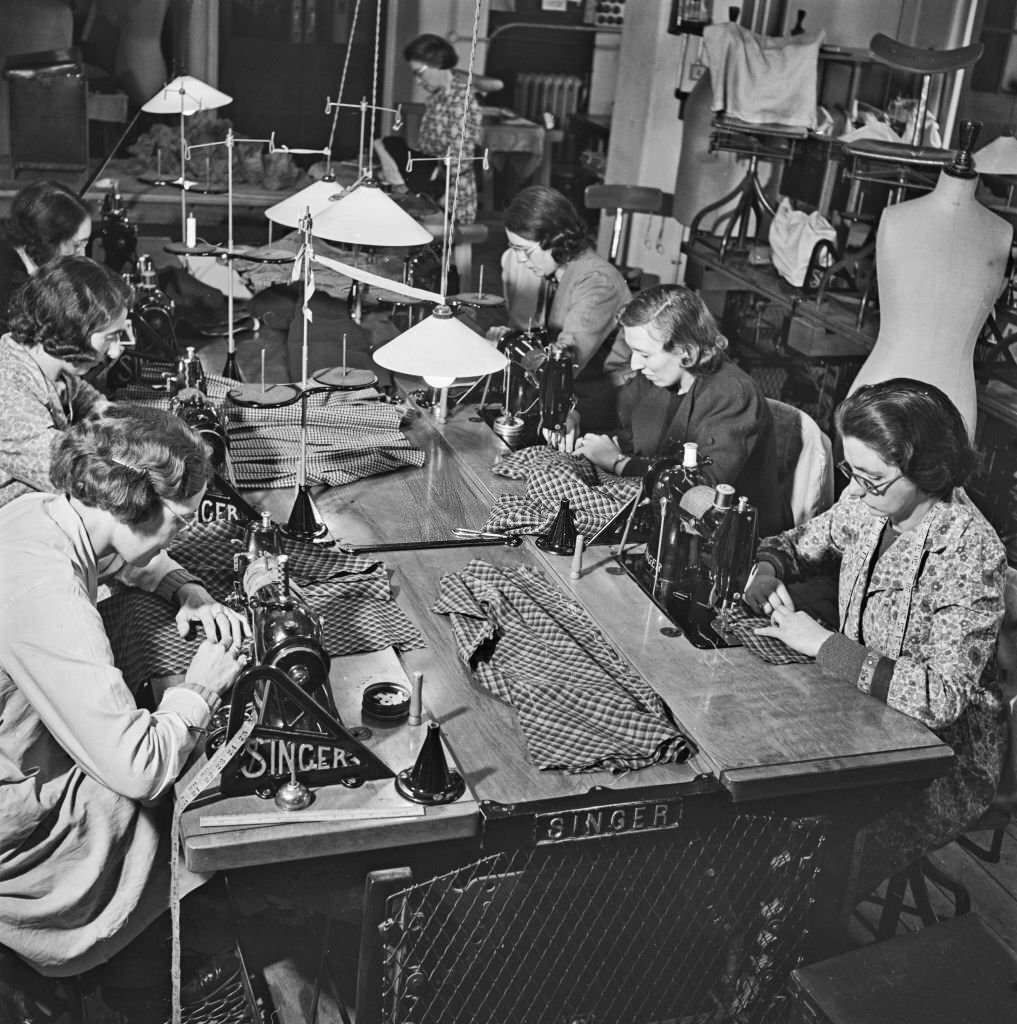#123 Seamstresses at work on sewing machines to create utility skirt suits to a design by Irish fashion designer Digby Morton at a Bourne and Hollingsworth department store workroom in London, 10th March 1942.
