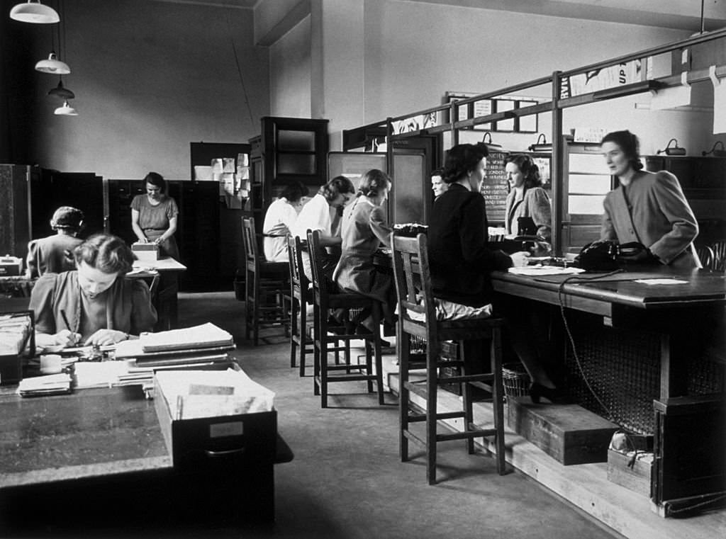 #128 Women applicants at the counter of Tooting Labour Exchange, signing up for employment in essential war work.