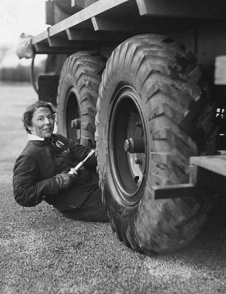 #14 A member of the Women’s Auxiliary Air Force working in the motor transport section greases the giant wheels of a lorry in Lancashire, 1939