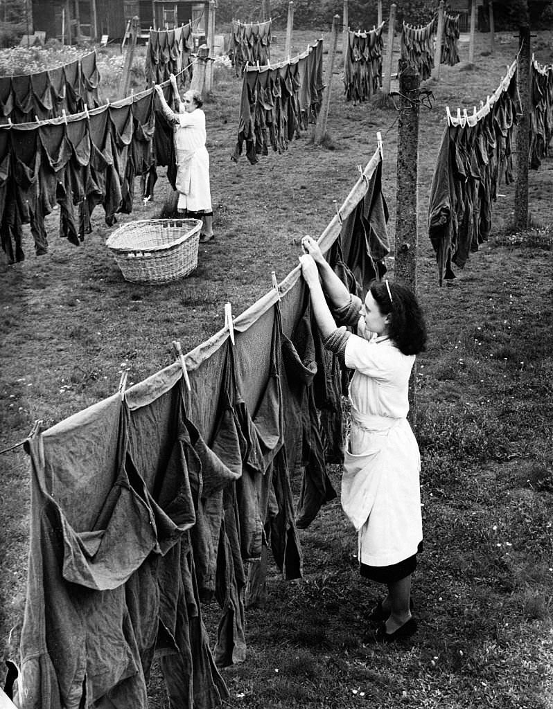 #149 Women hang out army shirts at a laundry in Surrey, England in 1941.