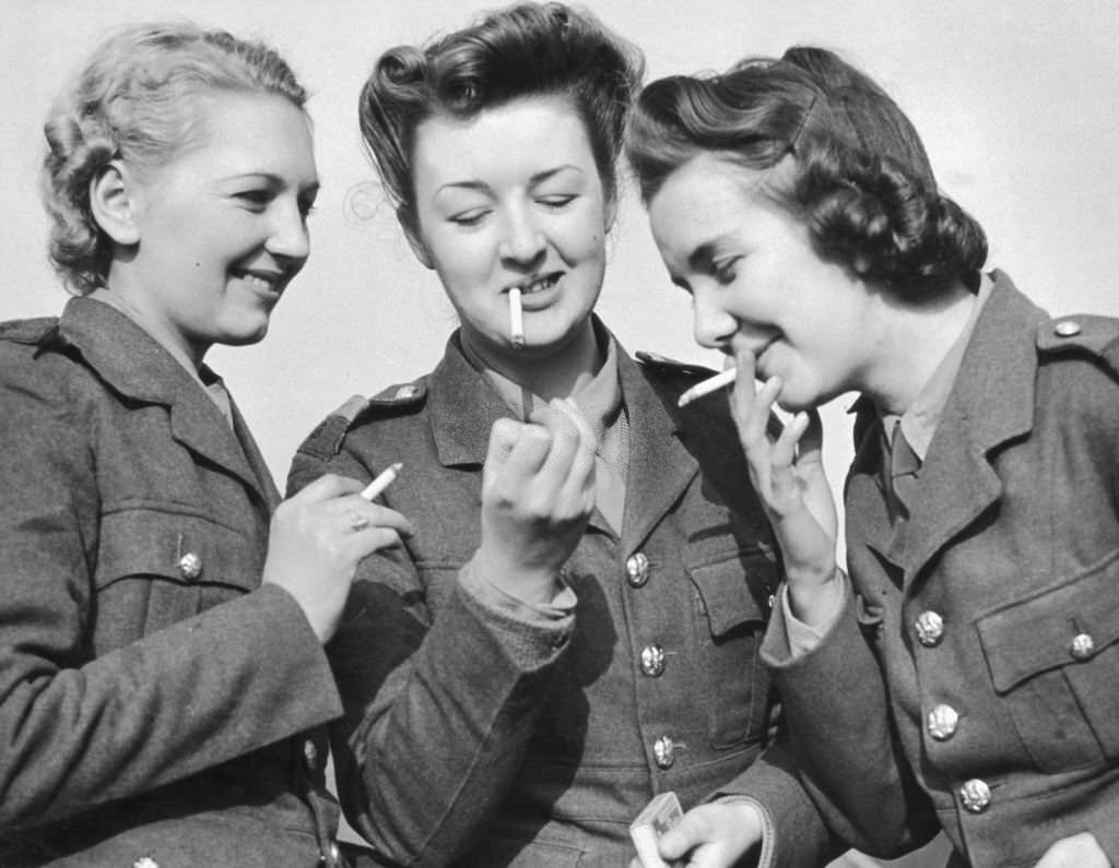 #33 Three women of the ATS light up together. ATS regulations forbid smoking when soldiers are wearing their hats, 1939